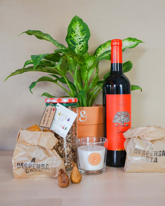 cabaz de oferta com planta, garrafa de vinho, vela e frutos secos da loja de plantas online curae